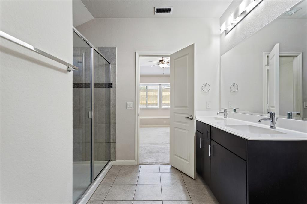 816 Harrison Lane Lavon, TX 75166 - Photo 20 of 40 a bathroom with a double vanity sink a large mirror and a shower