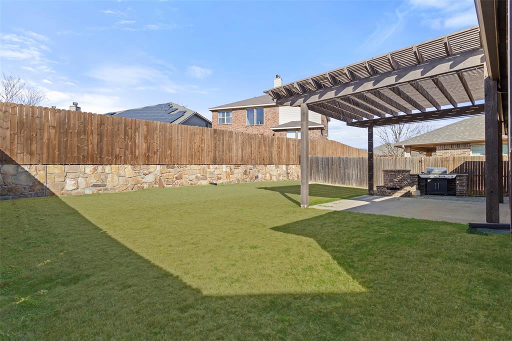 816 Harrison Lane Lavon, TX 75166 - Photo 32 of 40 a view of a backyard with table and chairs with wooden fence