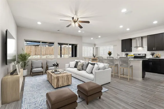 a living room with furniture kitchen and a wooden floor