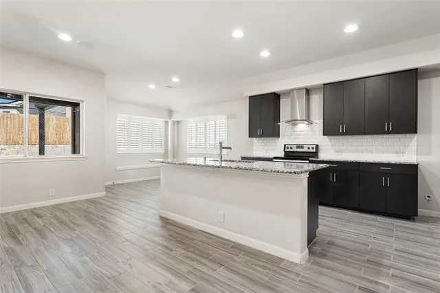 a kitchen with stainless steel appliances granite countertop a stove a sink and a microwave