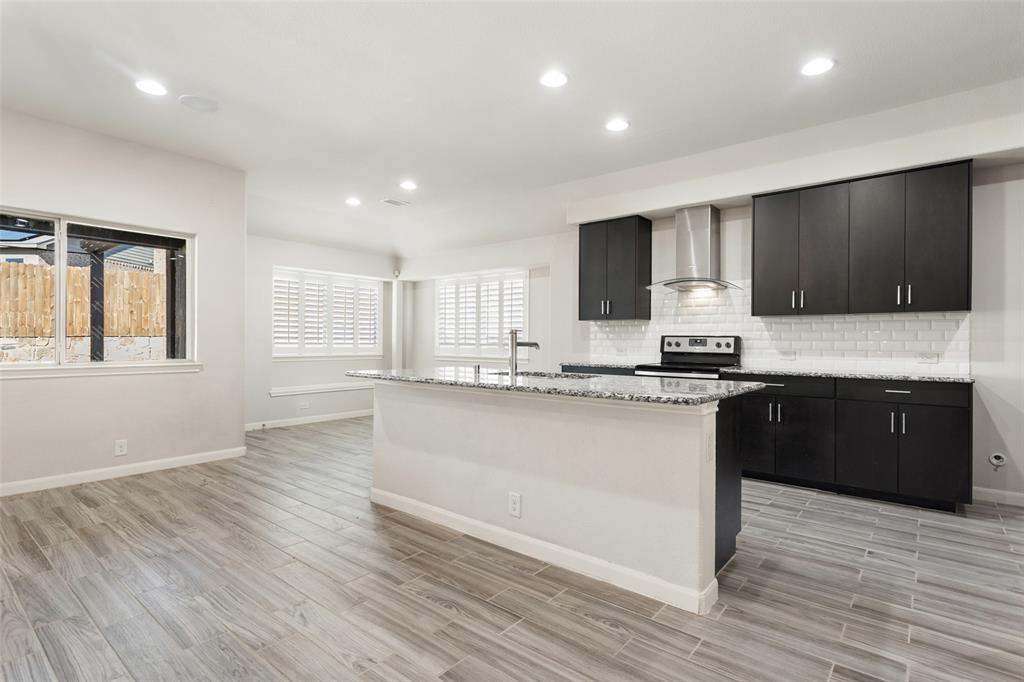 816 Harrison Lane Lavon, TX 75166 - Photo 7 of 40 a kitchen with stainless steel appliances granite countertop a stove a sink and a microwave