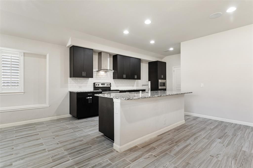 816 Harrison Lane Lavon, TX 75166 - Photo 9 of 40 a kitchen with stainless steel appliances kitchen island granite countertop a stove a sink and a refrigerator