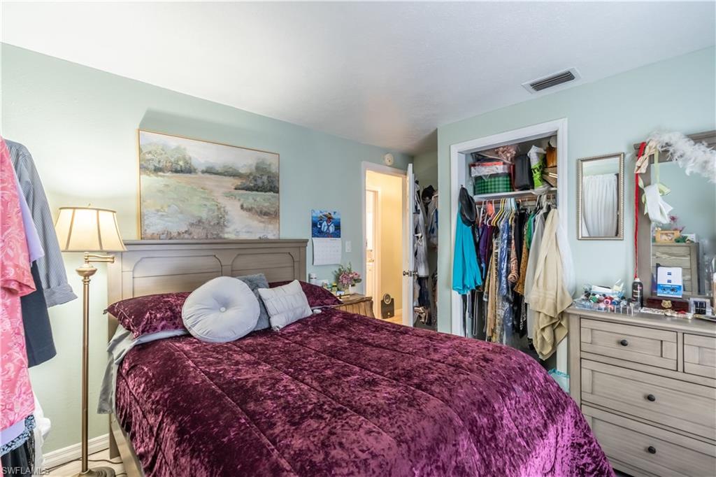 1360 5th Avenue North Naples, FL 34102 - Photo 11 of 45 a bedroom with a bed a large mirror and dresser