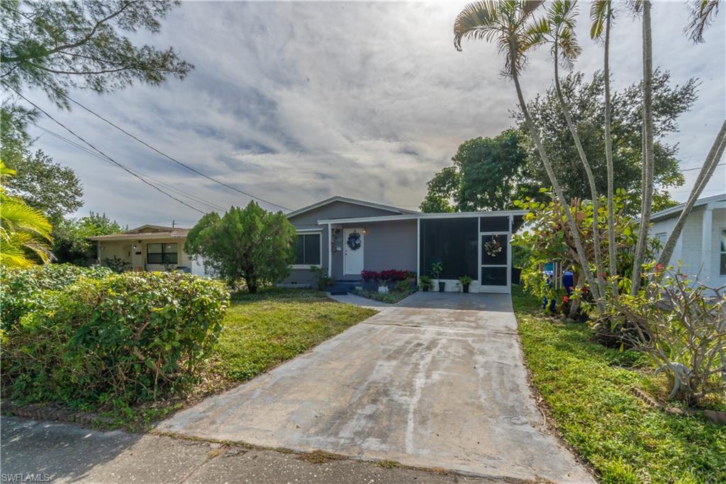 1360 5th Avenue North Naples, FL 34102 - Photo 24 of 45 a front view of a house with a yard and potted plants
