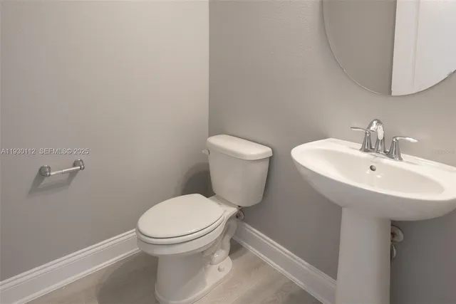 a white toilet sitting next to a bathroom sink