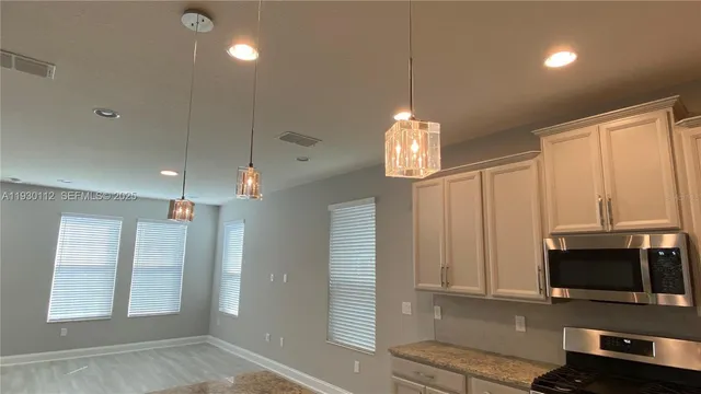 a view of a kitchen with microwave and cabinets