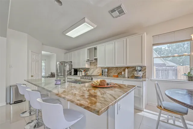 a kitchen with stainless steel appliances granite countertop a sink stove and cabinets