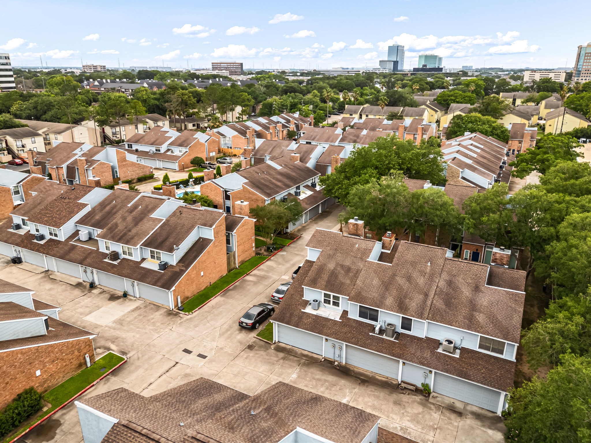 3200 South Gessner Road, Unit 228 Houston, TX 77063 - Photo 16 of 18 This stunning aerial view showcases the Townhomes at Westchase community nestled among mature trees with the Houston skyline visible in the distance, an unbeatable location in the heart of it all!