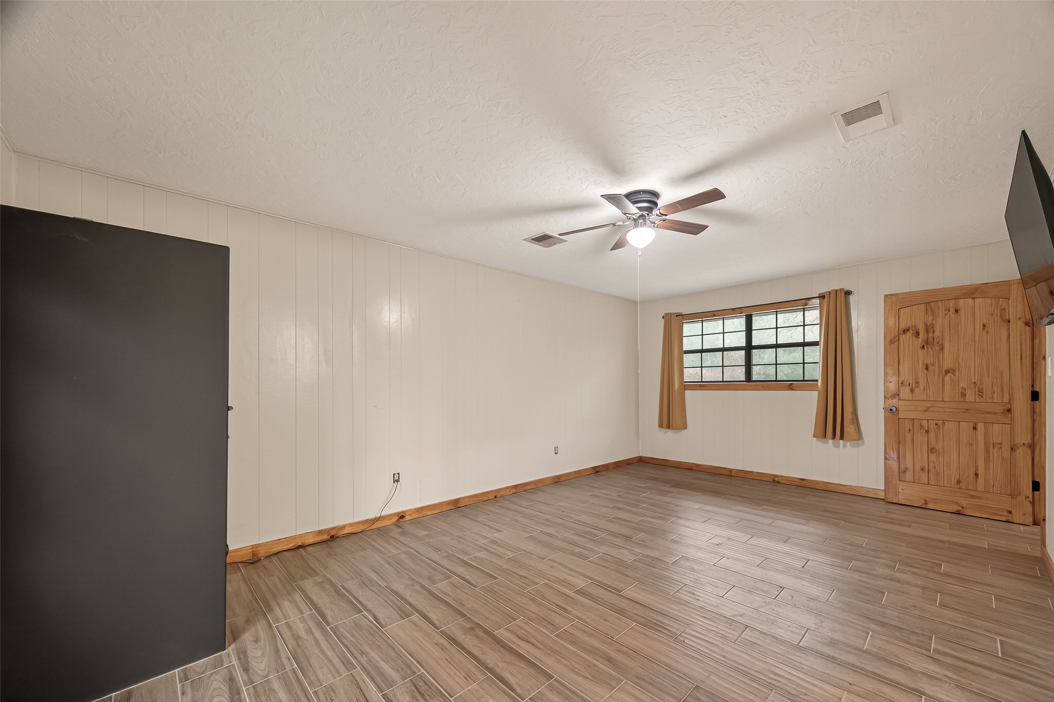 588 County Road 2307 Cleveland, TX 77327 - Photo 16 of 24 an empty room with wooden floor fan and windows