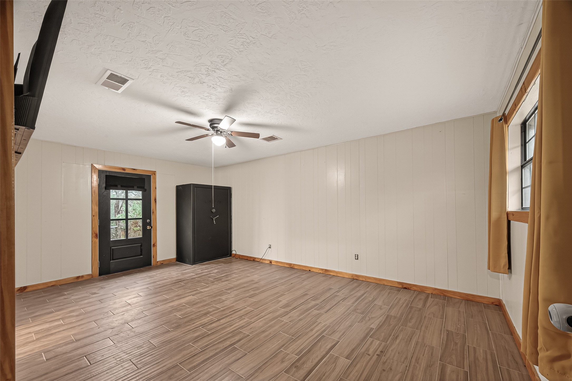 588 County Road 2307 Cleveland, TX 77327 - Photo 17 of 24 an empty room with wooden floor chandelier fan and windows