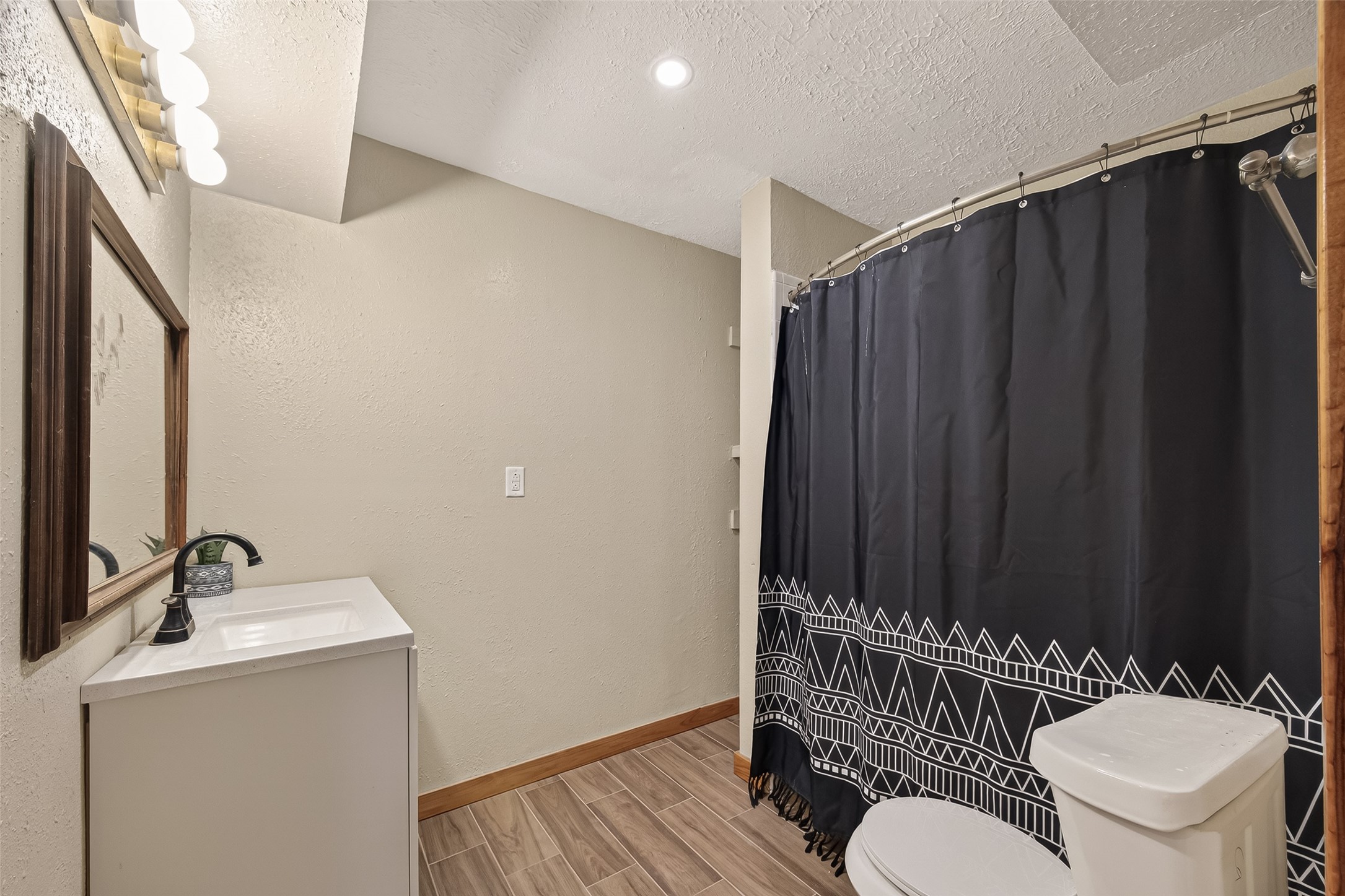 588 County Road 2307 Cleveland, TX 77327 - Photo 20 of 24 a bathroom with a sink a toilet a mirror and shower curtain