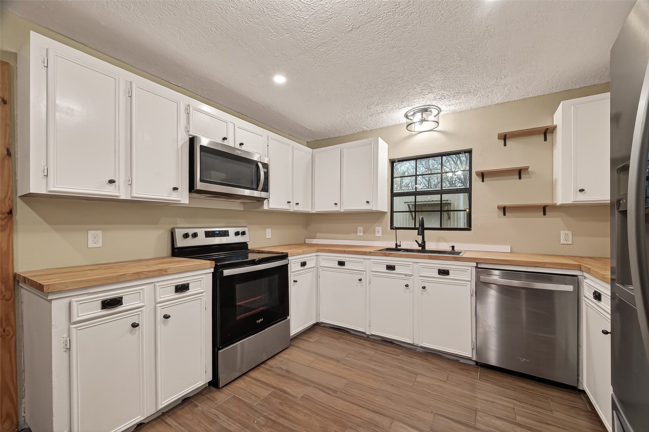 588 County Road 2307 Cleveland, TX 77327 - Photo 4 of 24 a kitchen with granite countertop white cabinets and white appliances