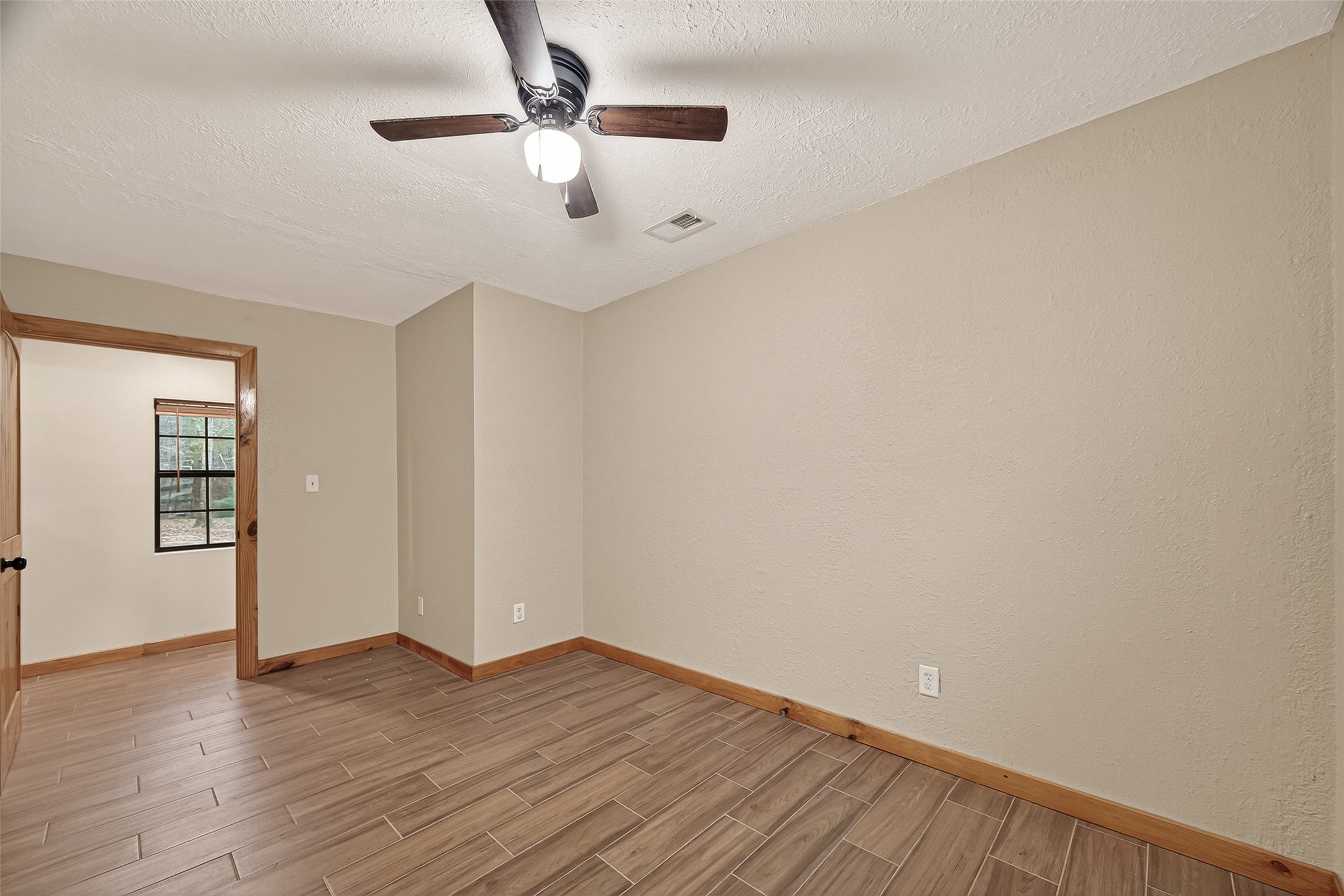 588 County Road 2307 Cleveland, TX 77327 - Photo 9 of 24 an empty room with wooden floor chandelier fan and windows