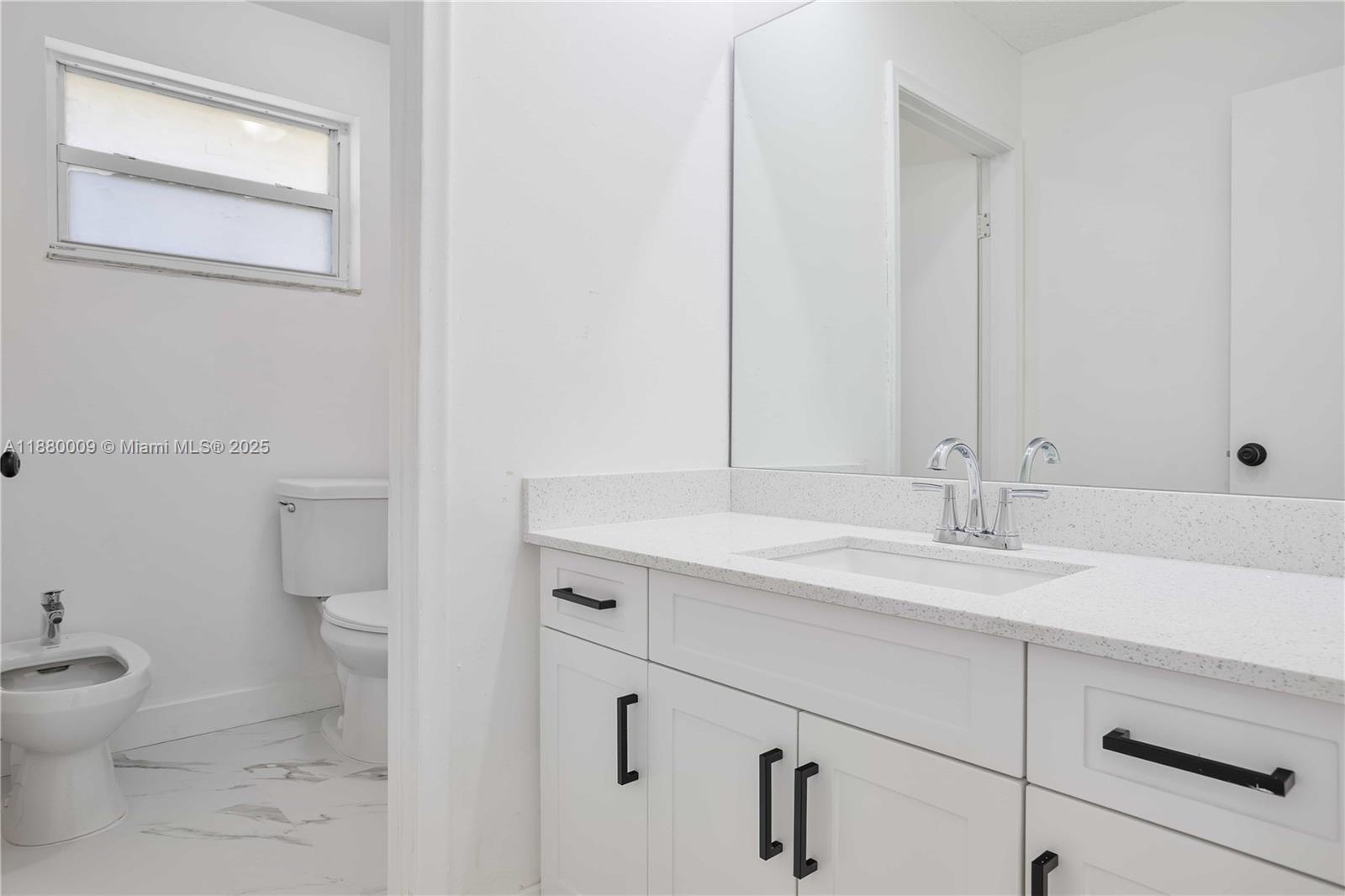 3524 Northwest 4th Terrace, Unit 1 Miami, FL 33125 - Photo 16 of 35 a bathroom with a granite countertop sink toilet and mirror