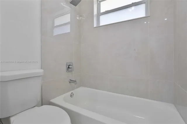 a bathroom with a toilet and bathtub