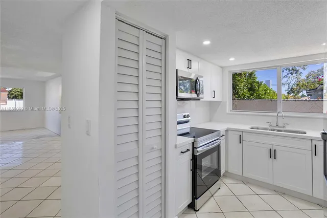 a kitchen with a sink cabinets and window