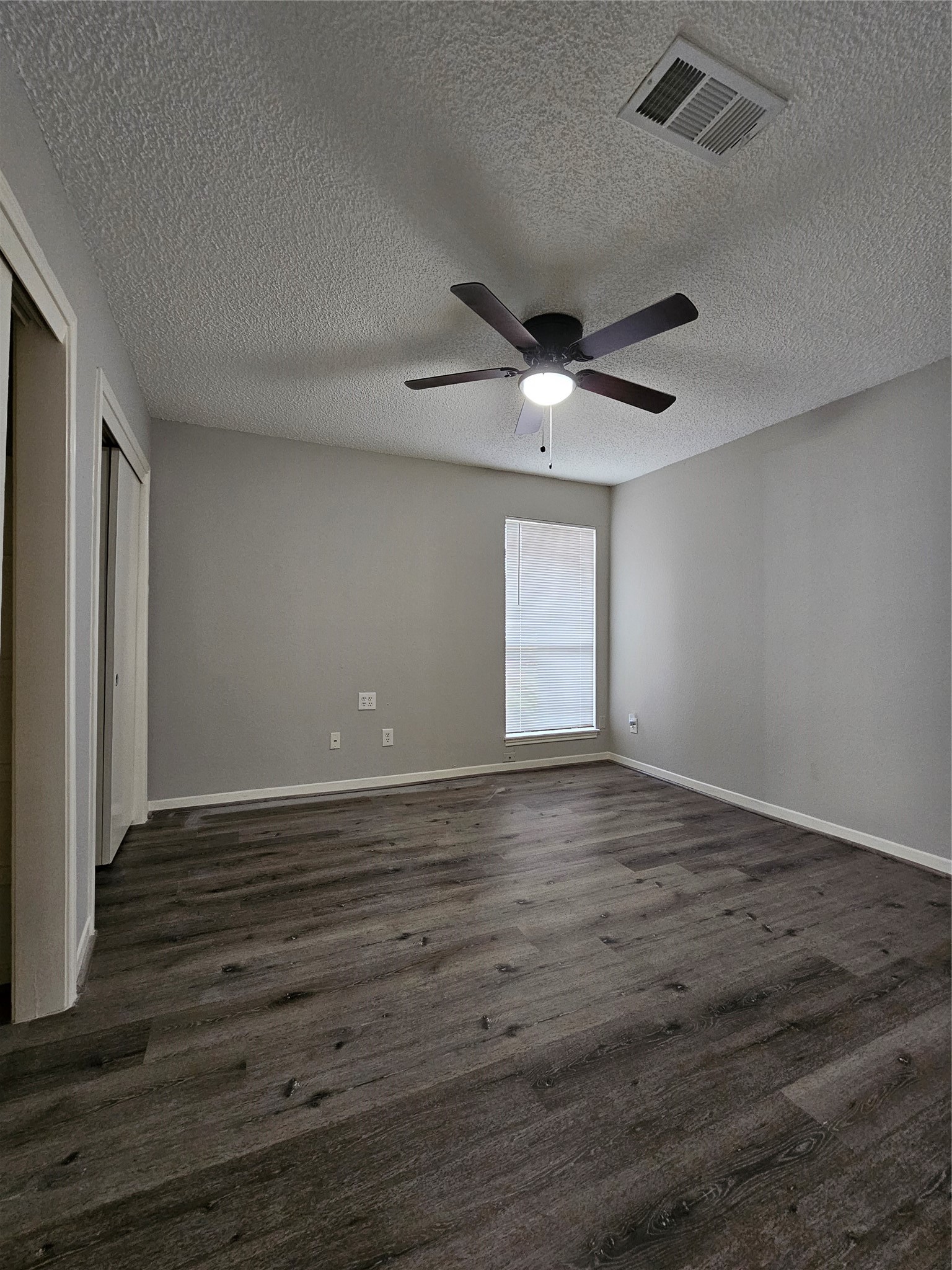 7887 Kendalia Drive Houston, TX 77036 - Photo 13 of 23 an empty room with wooden floor and windows