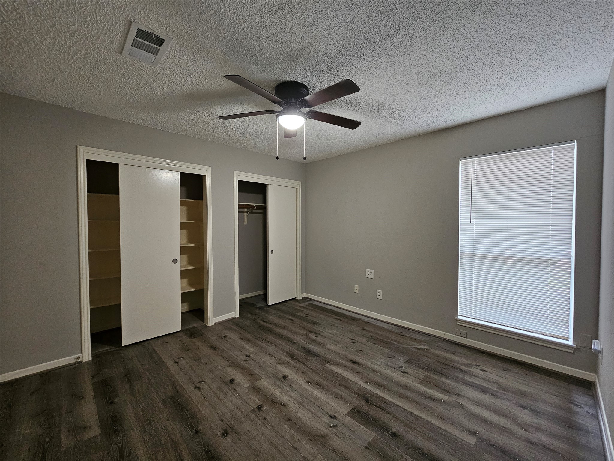 7887 Kendalia Drive Houston, TX 77036 - Photo 14 of 23 an empty room with wooden floor closet and ceiling fan