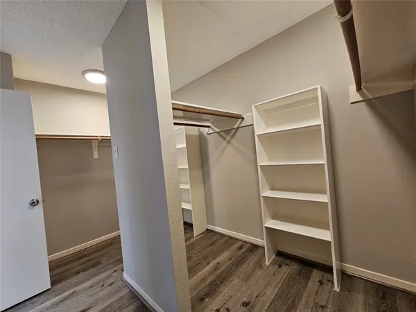 a view of walk in closet with wooden floor