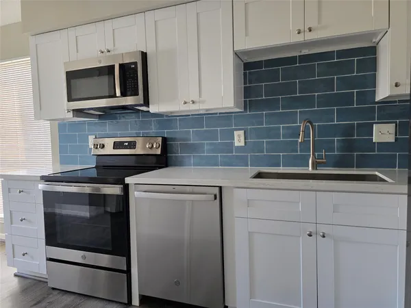 a kitchen with stainless steel appliances granite countertop a stove microwave and oven