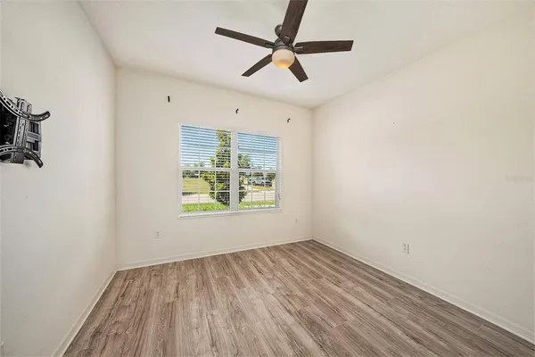 an empty room with a window and a ceiling fan