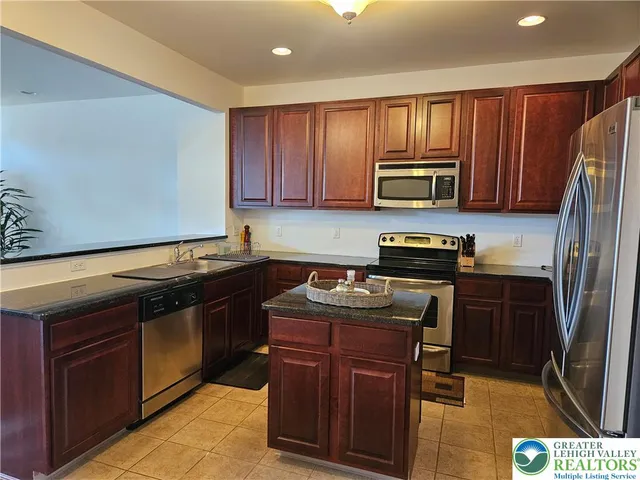 a kitchen with granite countertop wooden cabinets and stainless steel appliances