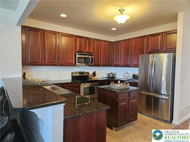 a kitchen with granite countertop stainless steel appliances and wooden cabinets