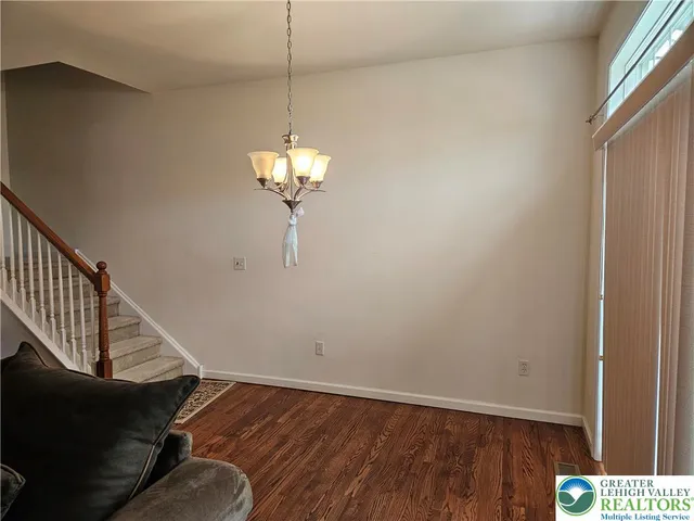 a view of a hallway with wooden floor and chandelier