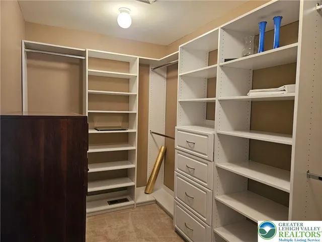 a view of walk in closet with empty racks