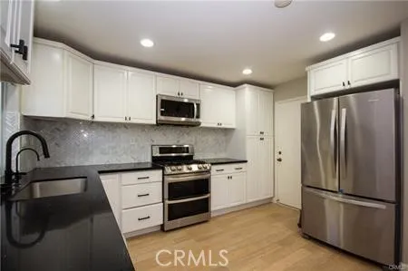 a kitchen with stainless steel appliances a refrigerator stove microwave and sink