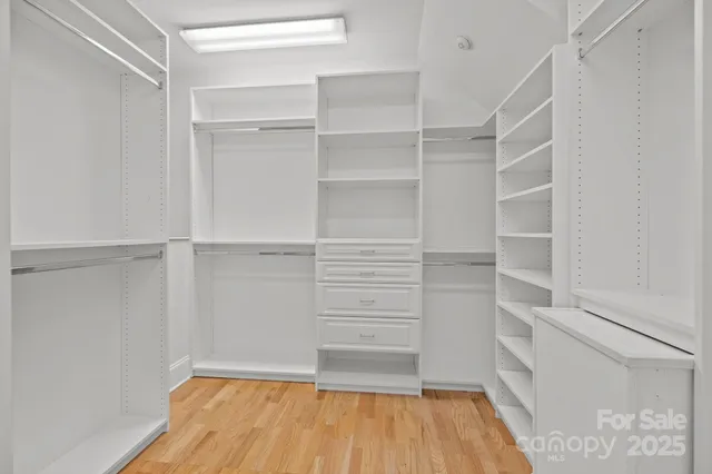 a room with walk in closet and wooden floor