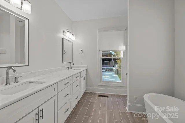 a spacious bathroom with a granite countertop sink toilet a large mirror a vanity and