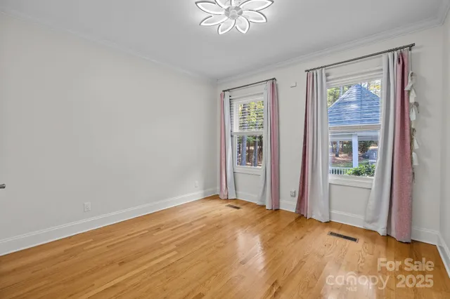 a view of a livingroom with a chandelier fan and wooden floor