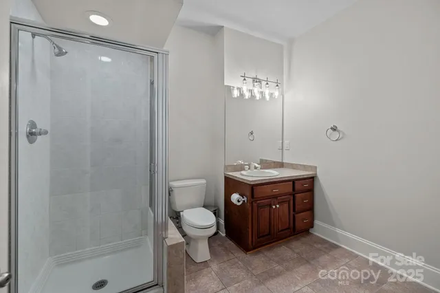 a spacious bathroom with a granite countertop sink a toilet and shower