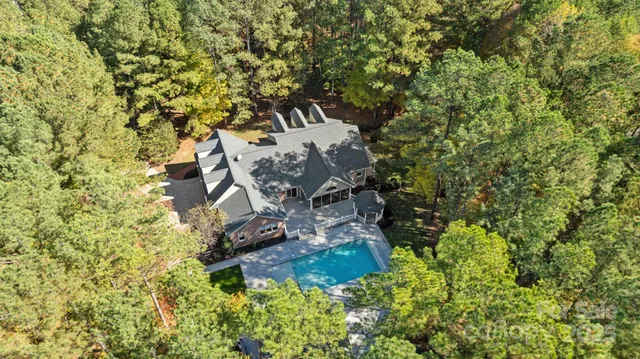 an aerial view of a house with a yard and trees