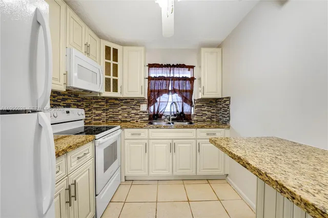 a kitchen with stainless steel appliances granite countertop a stove sink and cabinets
