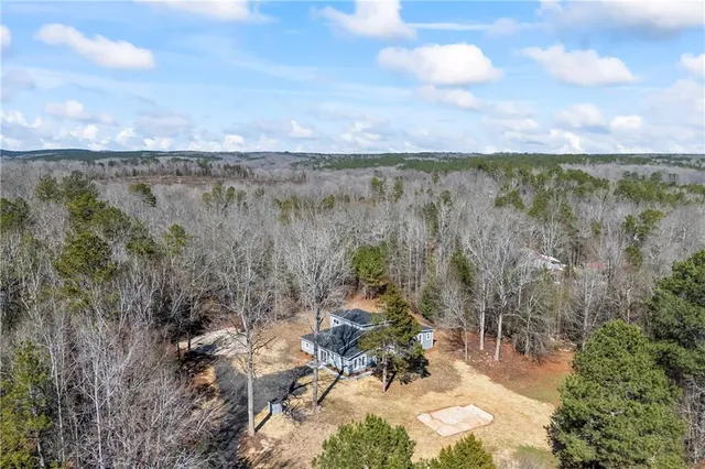 a spacious bedroom with two beds a chandelier and a window
