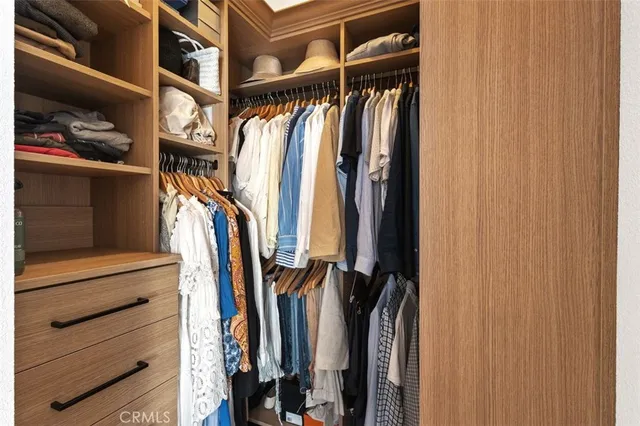 a view of walk in closet with clothes and shoes