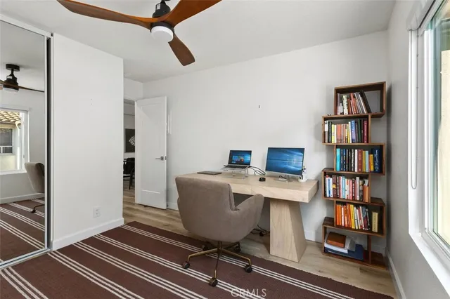 a view of a workspace with furniture and a book shelf