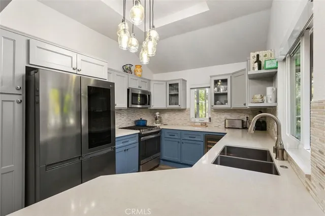 a kitchen with stainless steel appliances a sink stove and refrigerator