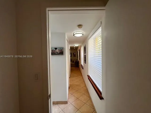 a view of a hallway with wooden floor and a bathroom