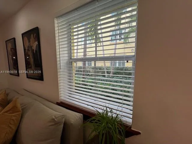 a view of a bedroom with a window and potted plants
