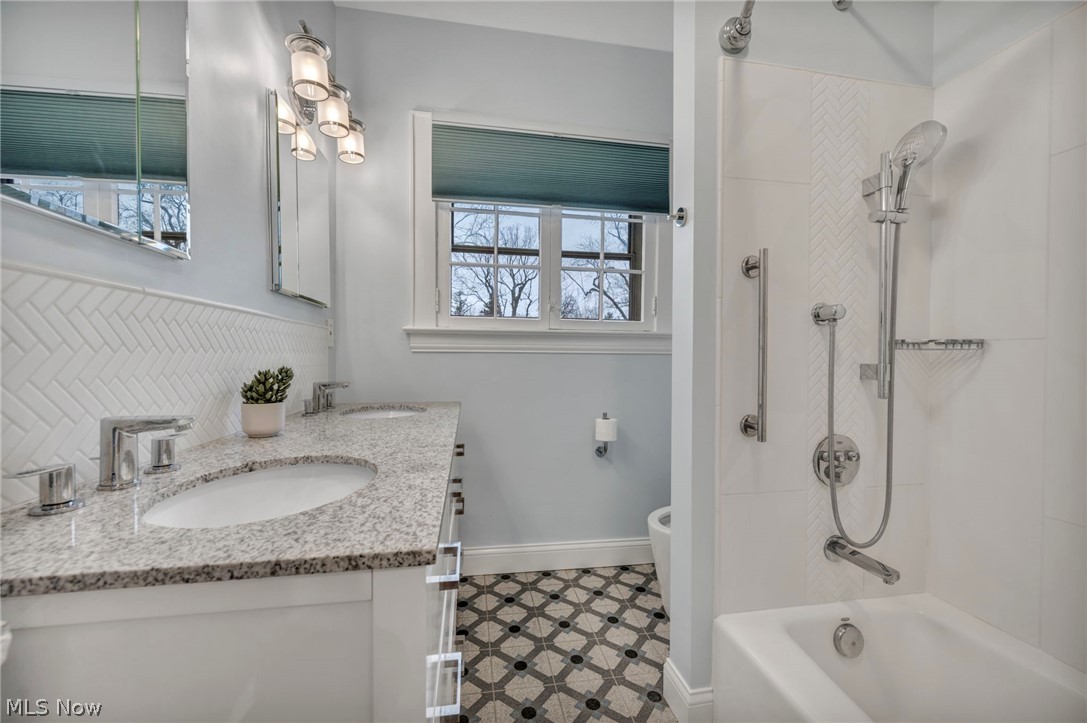 2914 Chadbourne Road Cleveland, OH 44120 - Photo 30 of 48 Full bathroom with toilet, dual sinks, vanity with extensive cabinet space, tub / shower combination, and tile flooring