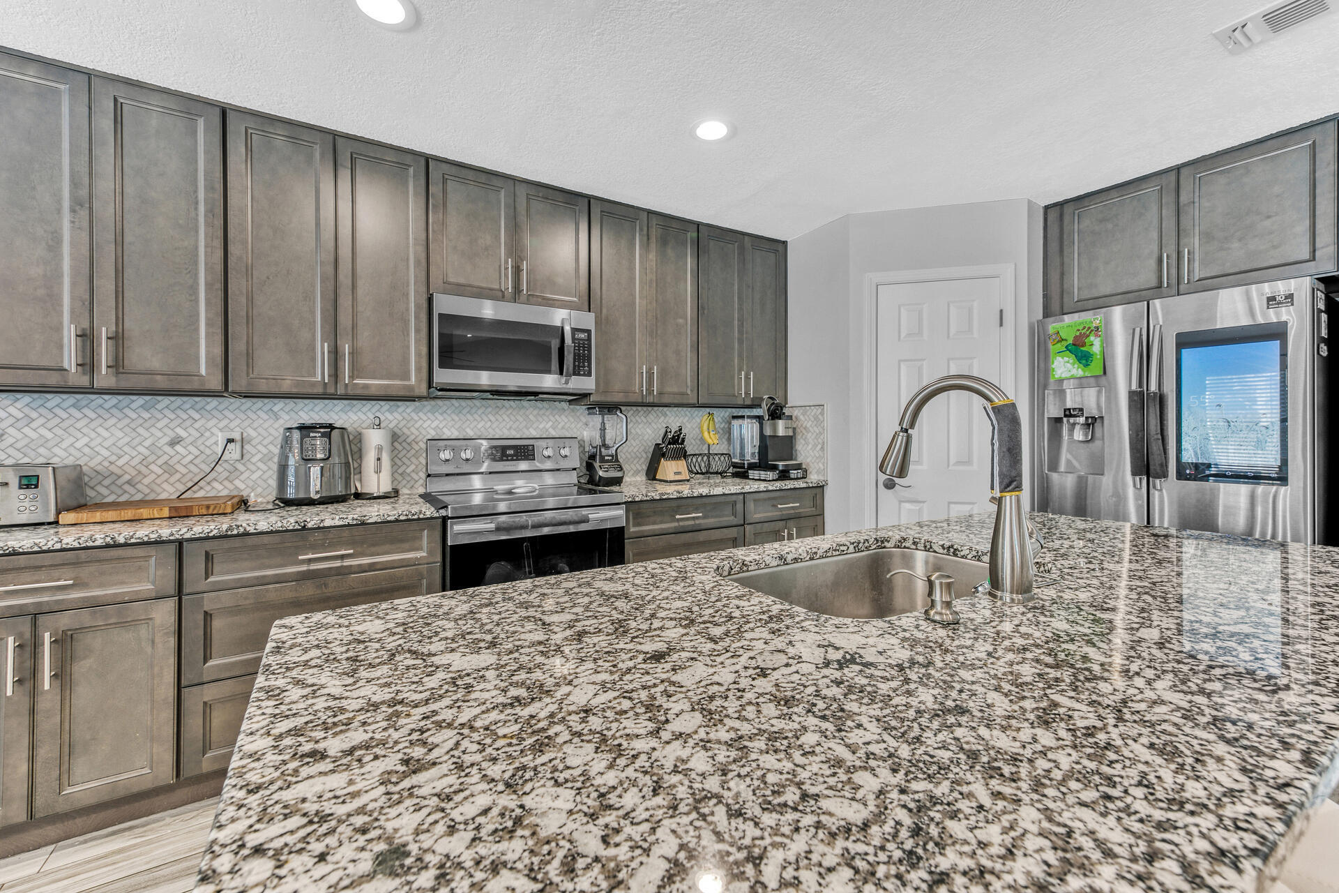 606 Risen Star Drive Crestview, FL 32539 - Photo 12 of 37 a kitchen with granite countertop wooden cabinets a sink and a stove