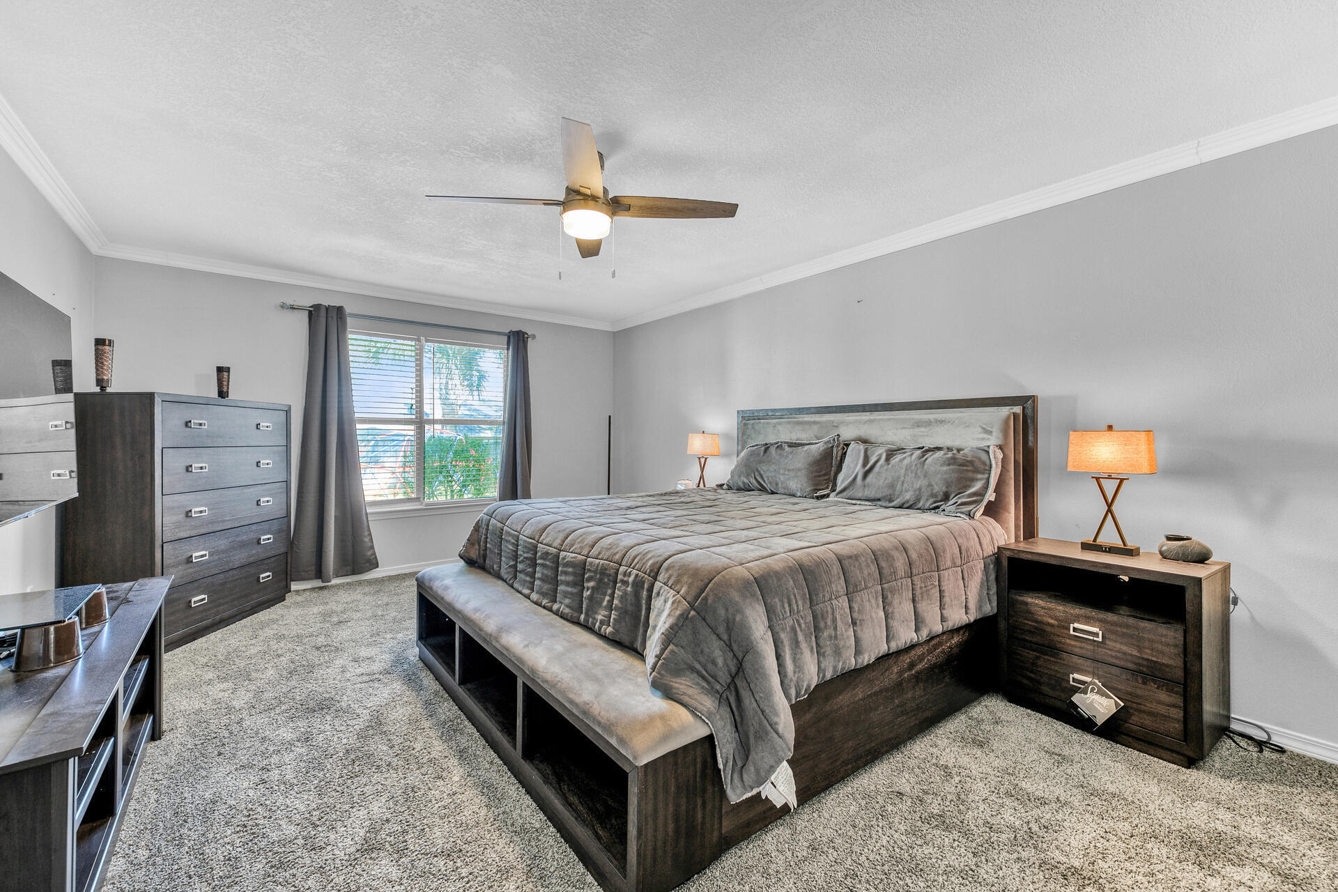606 Risen Star Drive Crestview, FL 32539 - Photo 17 of 37 a spacious bedroom with a bed a dresser and a chandelier
