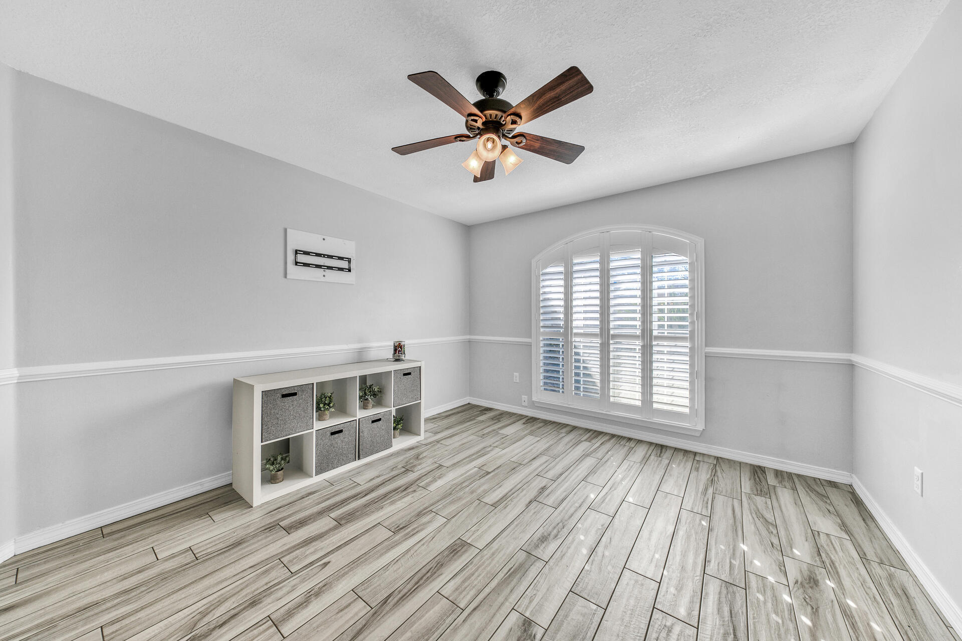 606 Risen Star Drive Crestview, FL 32539 - Photo 7 of 37 an empty room with wooden floor a ceiling fan and windows
