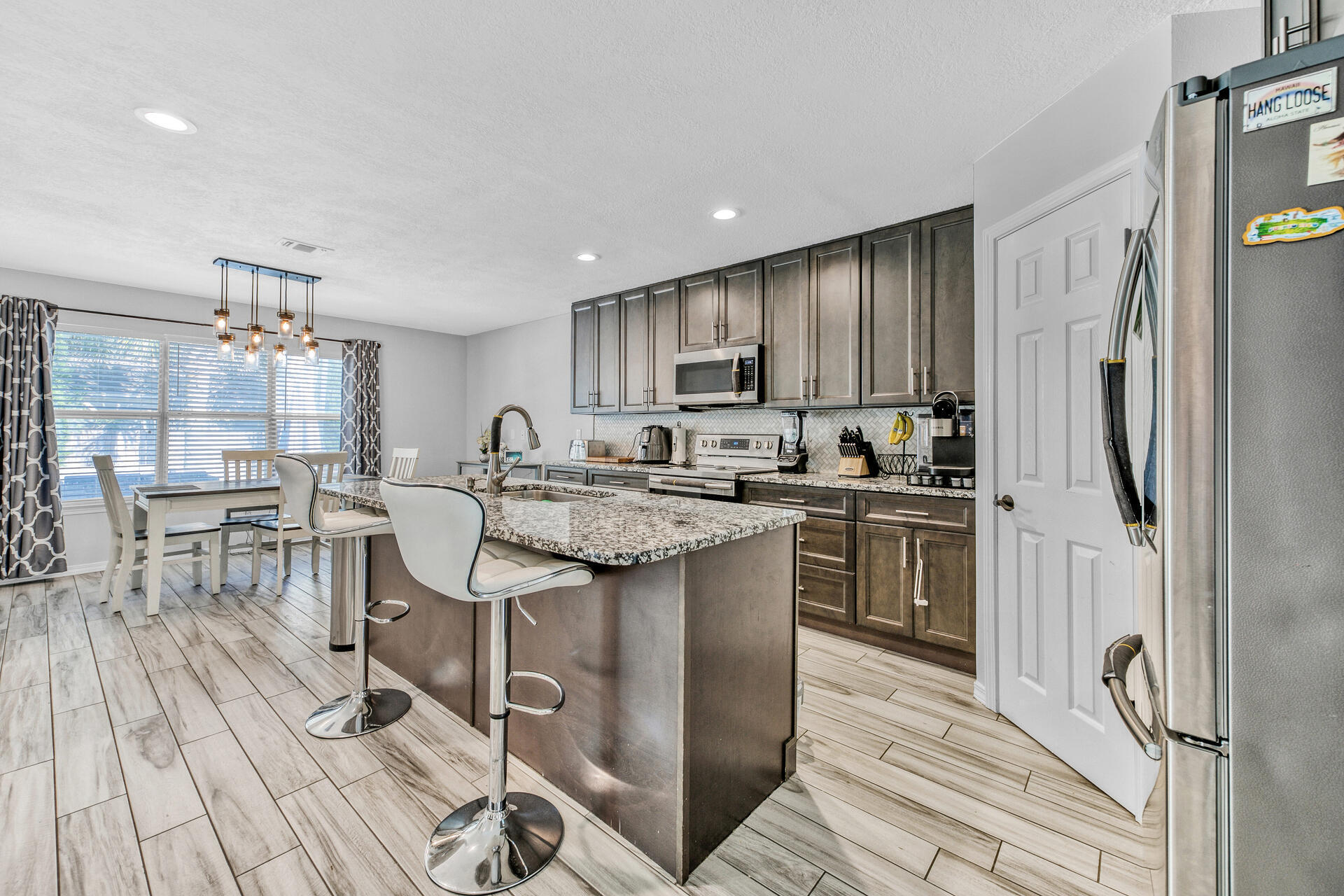 606 Risen Star Drive Crestview, FL 32539 - Photo 10 of 37 a kitchen with kitchen island granite countertop wooden floors and stainless steel appliances