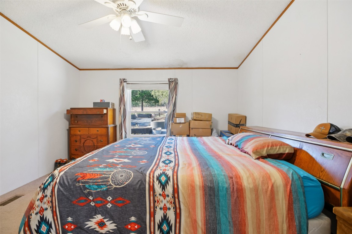 6975 Silvermine Road Harwood, TX 78632 - Photo 17 of 33 a bedroom with a bed and a chandelier