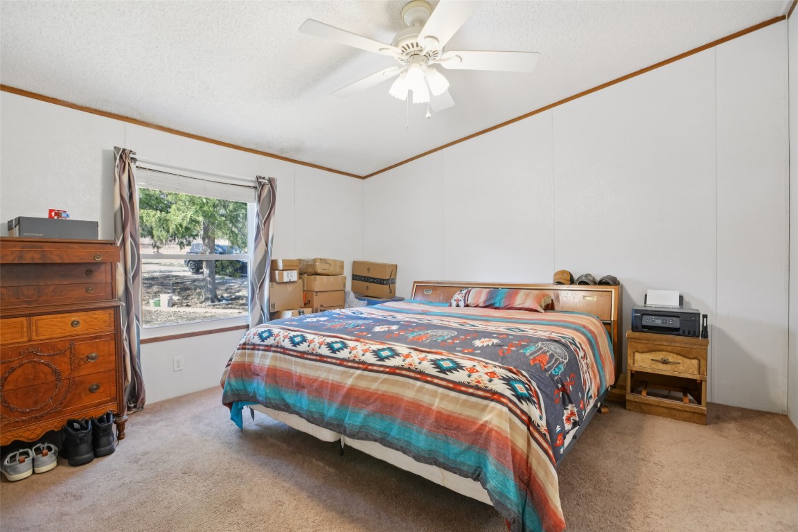 6975 Silvermine Road Harwood, TX 78632 - Photo 21 of 33 a bedroom with a bed and a chandelier