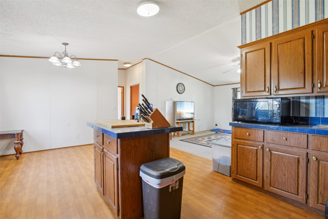 6975 Silvermine Road Harwood, TX 78632 - Photo 9 of 33 a kitchen with stainless steel appliances granite countertop a refrigerator a stove and white cabinets with wooden floor